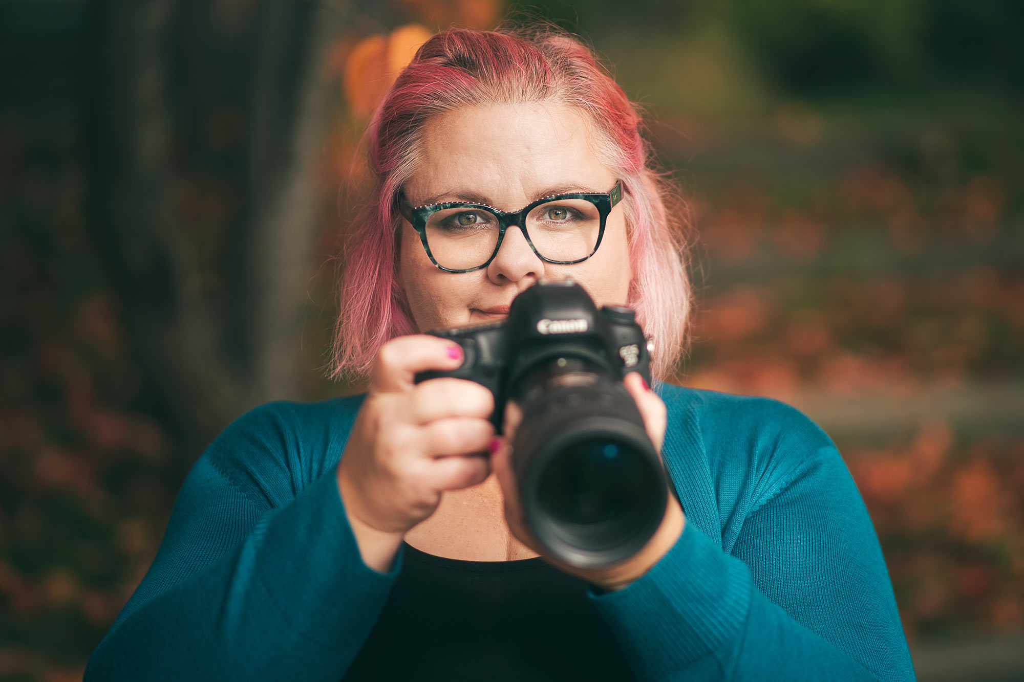 Fotograf Linda Holmkratz tittar fram bakom sin kamera.