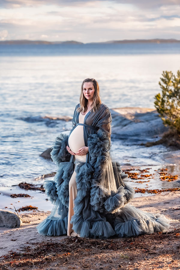 Gravidfotografering på stranden om vintern, som ser ut som sommar.